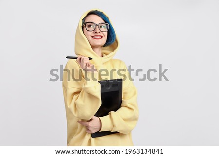 A female designer in yellow hoody holding graphic tablet. The white background Royalty-Free Stock Photo #1963134841