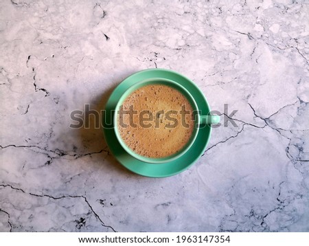Blue coffee cup and saucer shot on marble surface. Top view, from above, flat lay. Coffee break background.	
