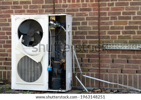 Broken air conditioning outside of a brick wall Royalty-Free Stock Photo #1963148251
