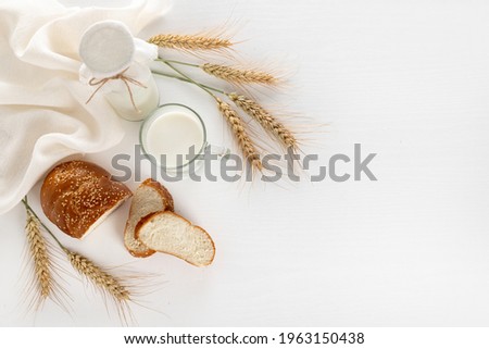 Dairy products and bread over white wooden background. Symbols of Jewish holiday - Shavuot. Top view Royalty-Free Stock Photo #1963150438
