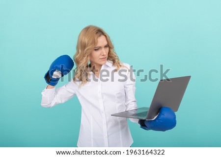 confident businesswoman in boxing gloves punching laptop, competition.