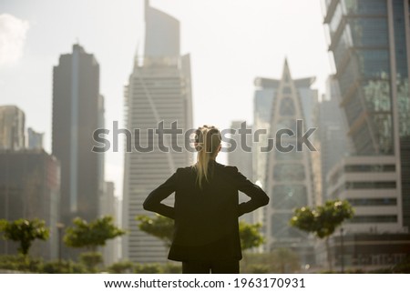 
Confident businesswoman standing strong looking at the city high-rises view. Business ambition and aspire. Royalty-Free Stock Photo #1963170931