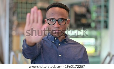 Portrait of Serious African Man showing Stop Sign by Hand