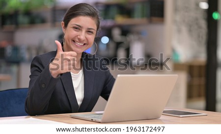 Appreciative Young Indian Businesswoman with Laptop doing Thumbs Up Royalty-Free Stock Photo #1963172497