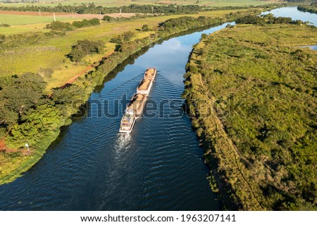 barge tug transporting commodity along the  river - Tiete-Parana Waterway Royalty-Free Stock Photo #1963207141