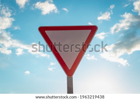 Road sign and blue sky with dark white clouds.