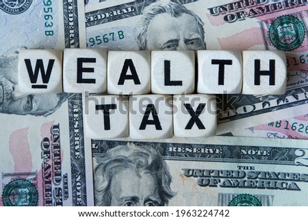 Wealth tax signage with a background of American dollars. Royalty-Free Stock Photo #1963224742