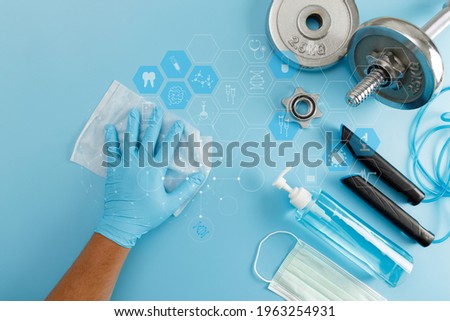 Fitness cleaning gym  Covid 19 virus using  alcohol spray anti virus concept Workout from home stay safe Royalty-Free Stock Photo #1963254931