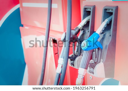Blue petrol pump filling nozzles at gas station, fuel gasoline dispenser.