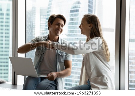 Happy diverse colleagues coworkers give fist bump celebrate online job success or work achievement. Smiling employees feel euphoric with good project results brainstorm together on computer in office. Royalty-Free Stock Photo #1963271353