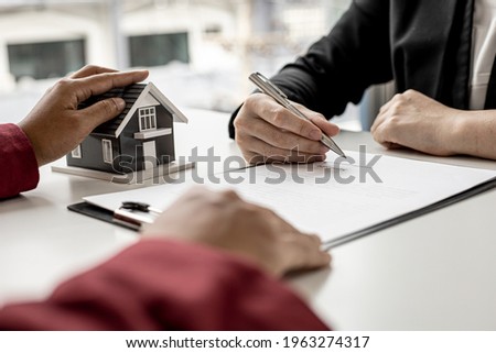 The tenant is signing a lease agreement with the landlord after viewing the home and discussing the rental agreement details. Real estate rental ideas.