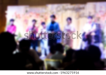 Abstract blurred background of master of ceremonies on stage at wedding ceremony in convention hall