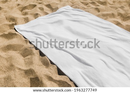 White beach towel on the sand Royalty-Free Stock Photo #1963277749