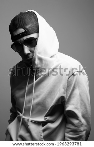 Man in Hood and sunglasses. stylish Boy in a hooded sweatshirt. black and white portrait