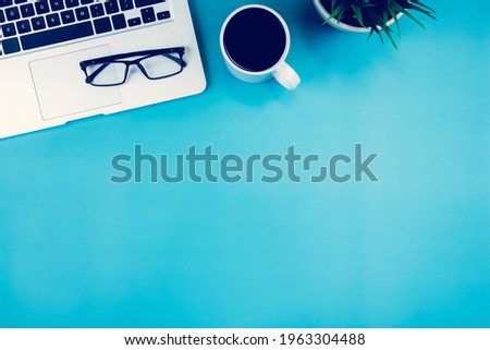 Flat lay, Laptop computer and plant and cup of coffee and glasses on desk in office, workplace and notebook and potted tree, workspace and copy space, top view, object with above, business concept.