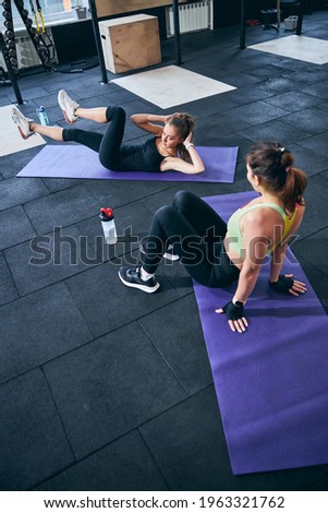 Young woman working her upper abdominal muscles Royalty-Free Stock Photo #1963321762