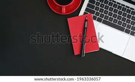 Black table with laptop, pen, coffee and notebook. Office desk concept.