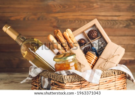 Gift basket with products on wooden background Royalty-Free Stock Photo #1963371043