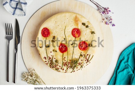 cake with a picture of flowers from tomatoes on a wooden base on a light background top view