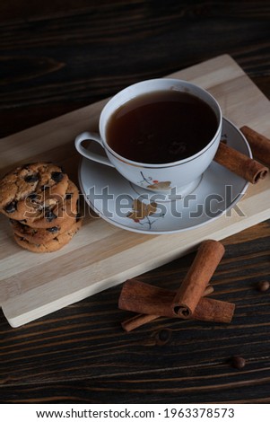 A cup of aromatic black coffee, grains of different varieties on the table and cinnamon sticks. Morning espresso or Americano coffee for breakfast in a beautiful cup. Still life. 