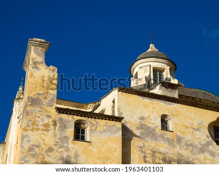 View of the bell tower of the Saint Jean Baptiste Calvi Cathedral. The Roman Catholic Church in the center of the high and ancient citadel of Calvi. Corsica, France. Royalty-Free Stock Photo #1963401103