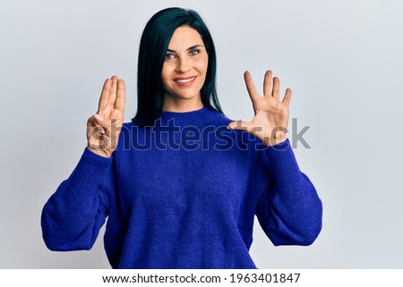 Young caucasian woman wearing casual clothes showing and pointing up with fingers number eight while smiling confident and happy. 