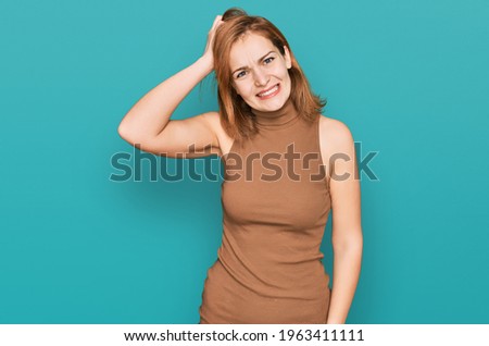 Young caucasian woman wearing casual clothes confuse and wonder about question. uncertain with doubt, thinking with hand on head. pensive concept. 