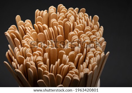 Wooden stirrers for coffee, tea and drinks in mug on a black background Royalty-Free Stock Photo #1963420801