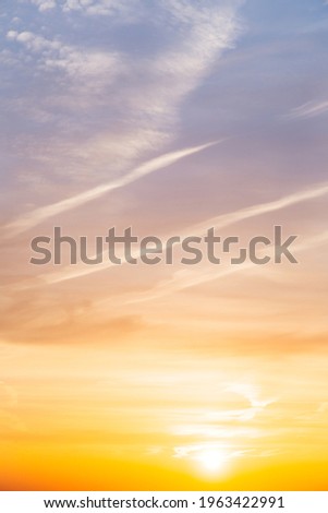 Beautiful bright summer sunset sky, yellow, orange and blue pastel color natural background, vertical picture photo