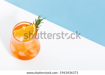 Aperol spritz  with ice an  glass, blue and white background, hard light, space for text Royalty-Free Stock Photo #1963436371