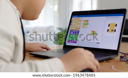 Young asia student remotely learn online at home in coding robot car and electronic board cable in STEM, STEAM, mathematics engineering science technology computer code in robotics for kids concept. Royalty-Free Stock Photo #1963478485