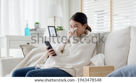 Young attractive beautiful asian female patient talk to doctor on cellphone videocall conference medical app in telehealth telemedicine online service hospital quarantine social distance at home. Royalty-Free Stock Photo #1963478548