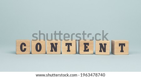 The word CONTENT made from wooden cubes on blue background. Conceptual photo