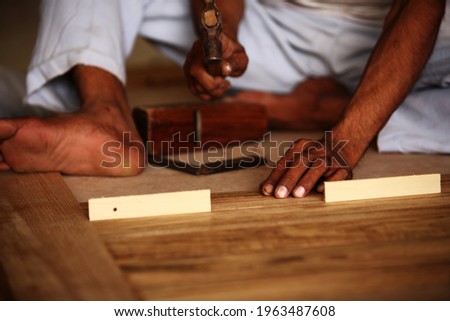 Royalty free photo of carpenter making modern Teak Wood pasted panel door.