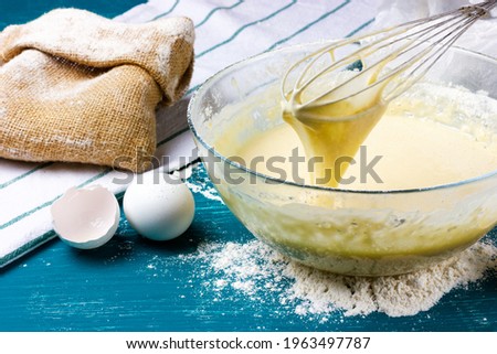 The batter drips off the whisk. Kneading wafer dough. Dough preparation process. Royalty-Free Stock Photo #1963497787