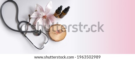 oil, tincture, medical stethoscope, creating a new medicine from plants, gifts of nature, dietary supplements, magnolia flowers, concept science, natural medicine, pharmacology, banner