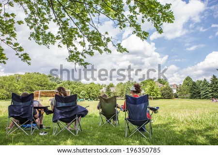 Parents sitting watching a childrens soccer game Royalty-Free Stock Photo #196350785