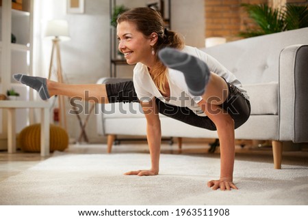 Young woman working out at home. Athletic woman in sportswear doing fitness stretching exercises.