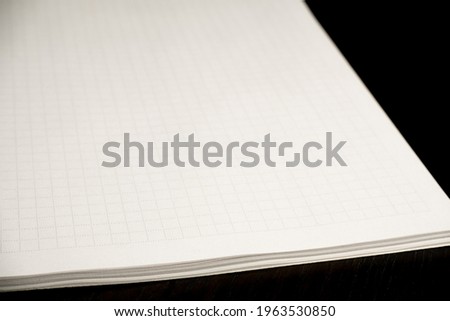 Open squared notebook on a black table