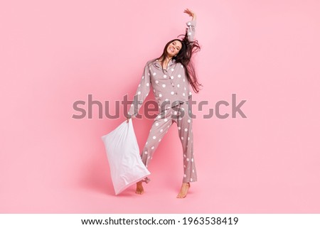 Full length photo of funky pretty young lady nightwear stretching dancing holding pillow isolated pink color background Royalty-Free Stock Photo #1963538419