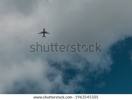 Airplane flying through the clouds seen from below