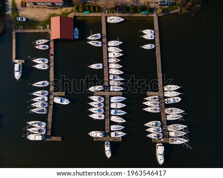boats moored in the marina, wooden footbridge, Masurian lakes. Aerial view, photos from the drone Royalty-Free Stock Photo #1963546417