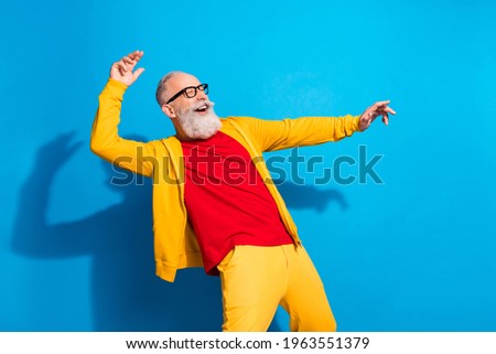Photo of funky funny good mood cheerful mature man in glasses dancing enjoying weekend isolated on blue color background
