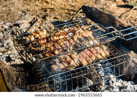 Fish barbecue preparing on charcoals at picnic