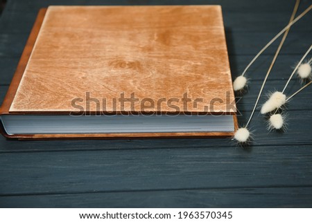 Luxury wooden photo book on natural background. Family memories photobook. Save your summer vacation memories. Photo album wedding photoalbum with wooden cover.