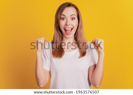 Close-up portrait of surprised beautiful girl celebrate victory open mouth scream on yellow wall