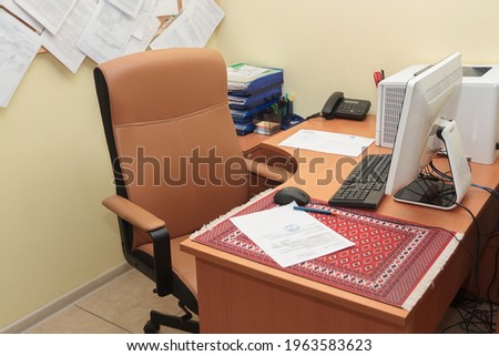 Office desk with leather armchair. A comfortable place to work with a desktop computer, printer and office supplies.
