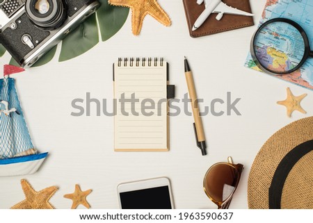 Top view photo of sunglasses sunhat camera map magnifier plane model on passport cover yacht toy smartphone palm leaf starfishes pen and notebook on isolated wooden white background with copyspace