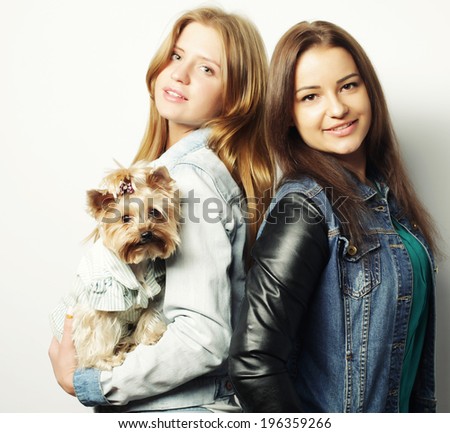 two happy teenage sisters with Yorkshire Terrier