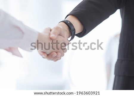 Blur picture about Two business people holding hands to business cooperate,business concept.